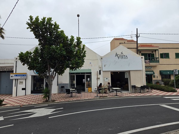 Entrée de la pizzeria Avista Pizza Society avec grandes portes ouvertes, tables sur la place et ambiance décontractée.