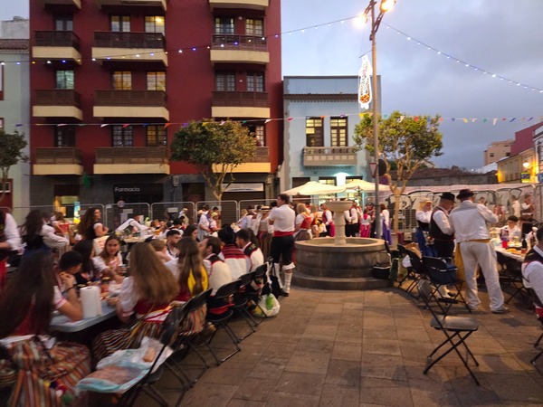 Longues tables installées sur une place historique de La Laguna, familles et groupes partageant le souper des fêtes.