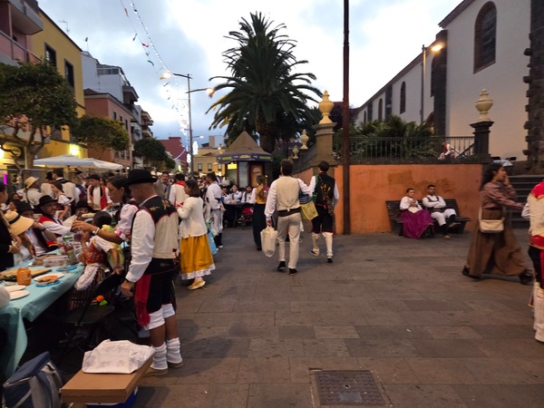 Vue d’ensemble du Baile de Magos à La Laguna au crépuscule, avec habitants en costume traditionnel autour de la place.
