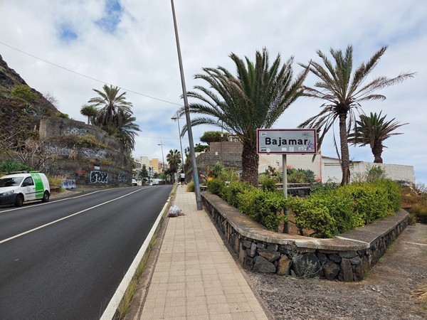 Panneau d’entrée indiquant Bajamar avec palmiers et route en arrière-plan.