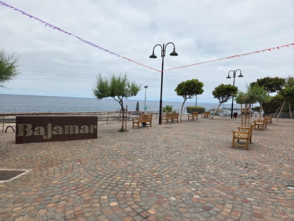 Grande place pavée de Bajamar avec bancs et vue sur l’océan.