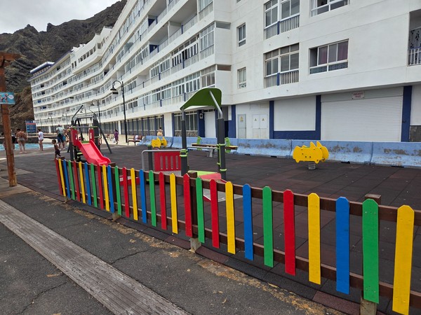 Aire de jeux clôturée et colorée près des piscines de Bajamar.