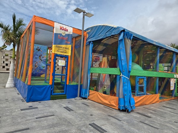 Zone de jeux pour enfants Kids Land avec structures protégées et entrée signalée au Rosa Center.