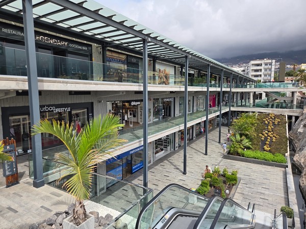 Perspective intérieure du Rosa Center avec passerelles, escalators et nombreuses vitrines le long des galeries.