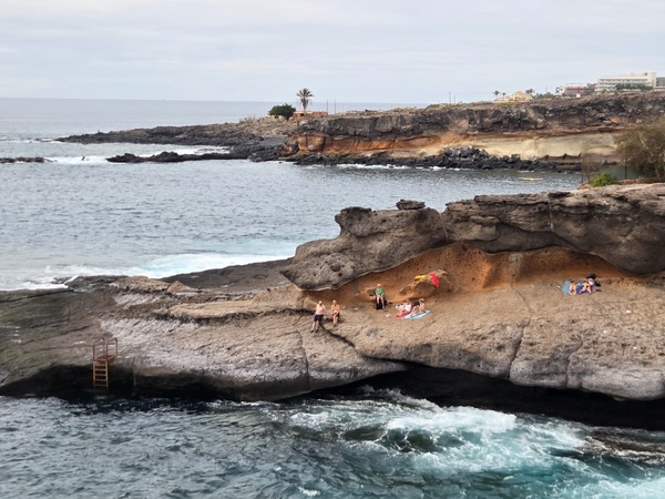Plateforme rocheuse avec baigneurs et échelle dans la mer à proximité d’El Puertito.