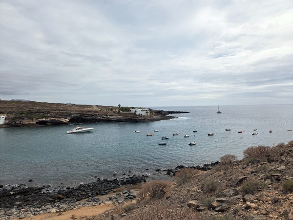 Embarcations mouillées dans la baie abritée d’El Puertito avec la côte volcanique en arrière-plan.