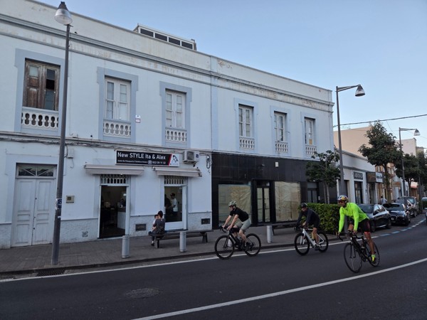 Groupe de cyclistes passant devant un salon de coiffure et d’esthétique à Güímar.