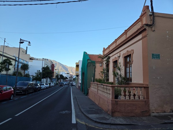 Rue résidentielle de Güímar avec maisons colorées et montagnes en toile de fond.