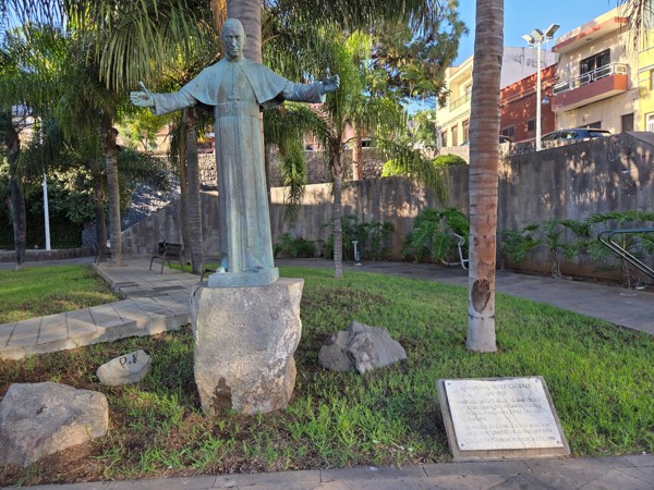 Statue de religieux bras ouverts installée dans un parc verdoyant de Güímar.