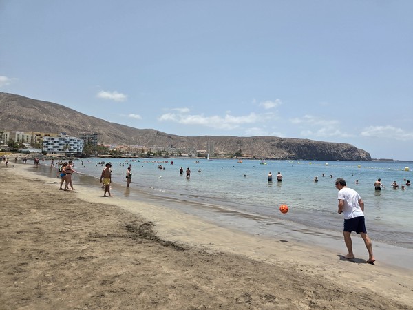 Vacanciers jouant au ballon au bord de l’eau sur la plage de Los Cristianos à Tenerife.