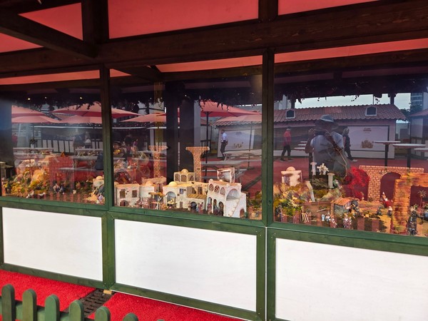 Grande crèche de Noël exposée dans une vitrine au marché de Noël d’El Corte Inglés, avec maisons, ponts et nombreuses figurines.