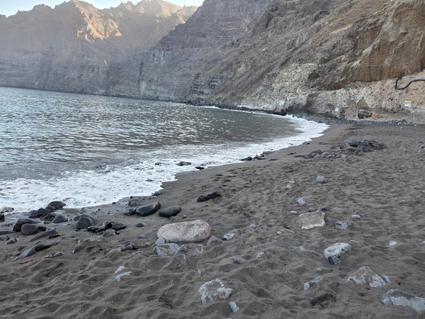 Sable volcanique sombre avec quelques galets sur la Playa de Los Guíos.