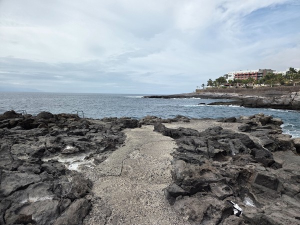 Accès naturel au bord de mer sur les rochers d’El Marquéz, avec plusieurs échelles en métal pour entrer dans l’eau.