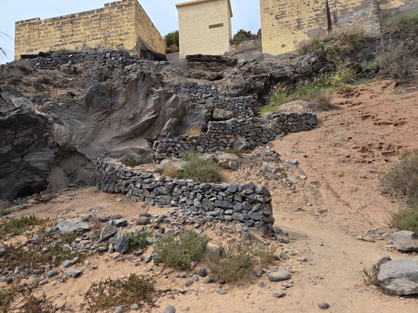 Petites terrasses et murets en pierre volcanique menant à la plage de Playa Las Salinas.
