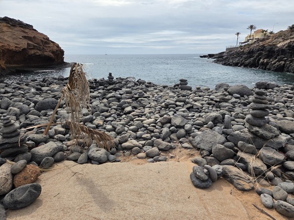 Vue rapprochée des galets volcaniques et de la petite anse protégée de Playa Las Salinas.