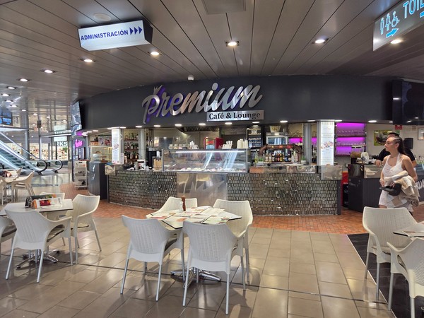 Comptoir du Premium Café & Lounge au Plaza del Duque avec tables blanches et carte variée pour petit-déjeuner ou goûter.