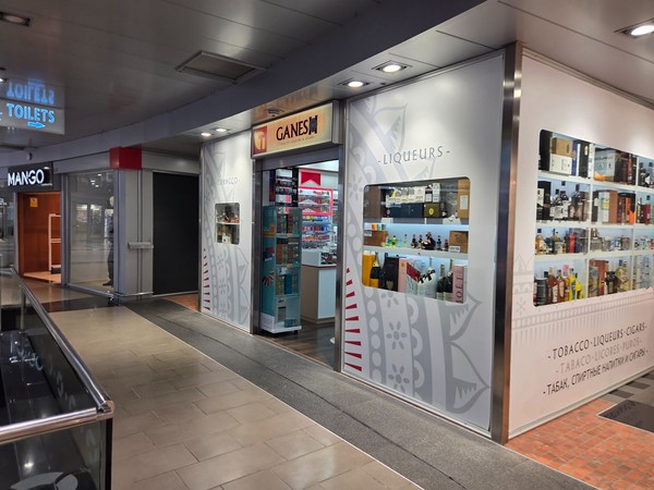 Boutique Ganesha Tabac & Liqueurs avec présentoirs de boissons, cigares et souvenirs.