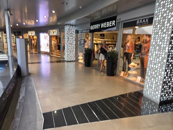 Galerie intérieure avec la boutique Gerry Weber et BRAX, mannequins et vitrines éclairées.