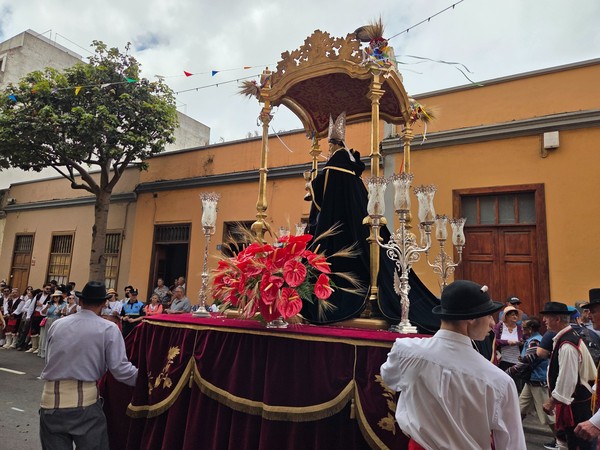Char religieux portant l’image de San Benito Abad décoré de fleurs et d’épis de blé.